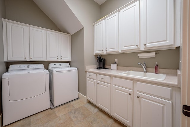 washroom with washing machine and dryer, a sink, and cabinet space