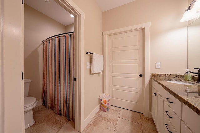 full bath with toilet, tile patterned floors, baseboards, and vanity