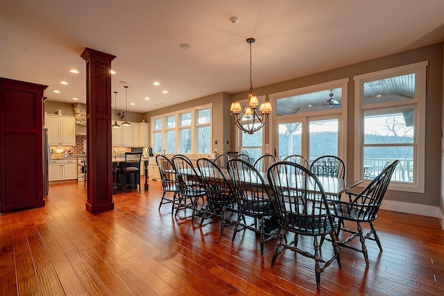 dining area with a notable chandelier, decorative columns, recessed lighting, visible vents, and hardwood / wood-style flooring