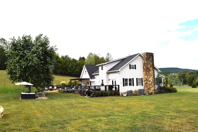 back of house with a yard, cooling unit, and a wooden deck