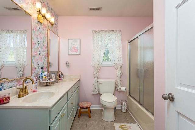 full bathroom with combined bath / shower with glass door, vanity, tile patterned floors, and a wealth of natural light