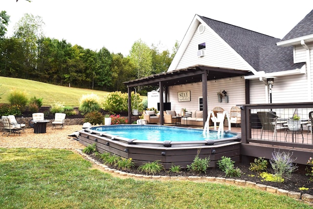 view of swimming pool with outdoor lounge area, a yard, and a deck