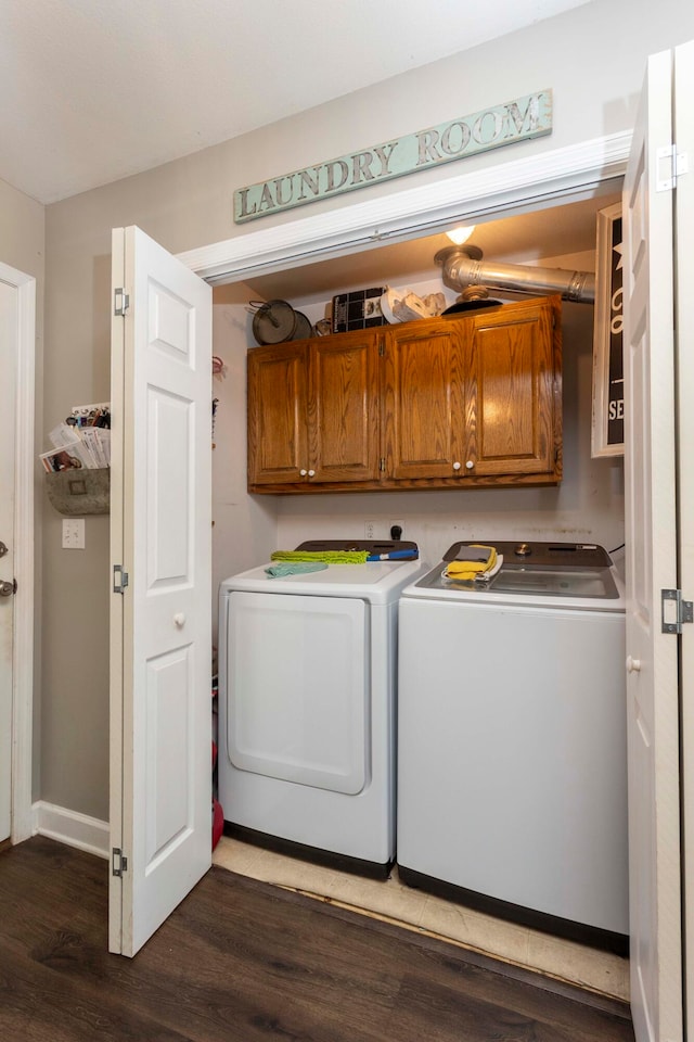 laundry room with cabinets, dark hardwood / wood-style floors, and washing machine and clothes dryer