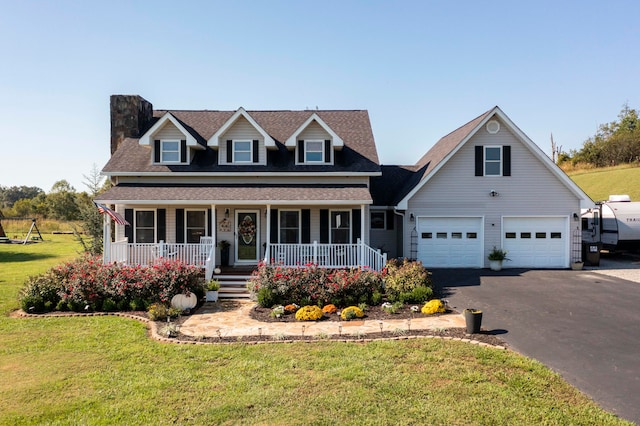 view of front of home with covered porch, a front yard, and a garage