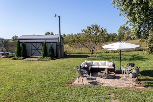 view of yard with a storage shed, a patio area, an outdoor living space with a fire pit, and a trampoline