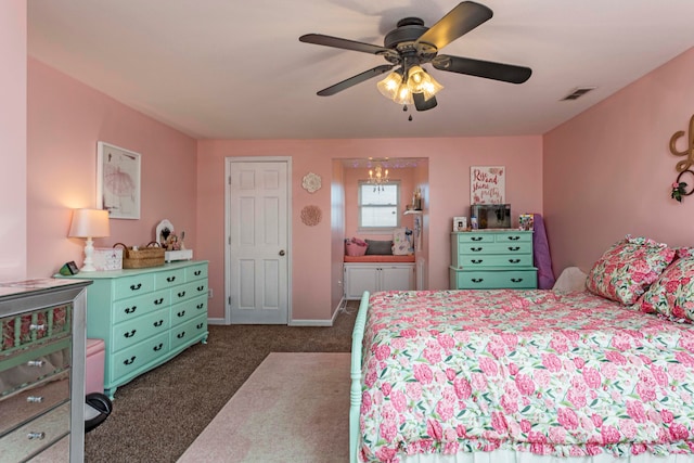 carpeted bedroom featuring ceiling fan with notable chandelier