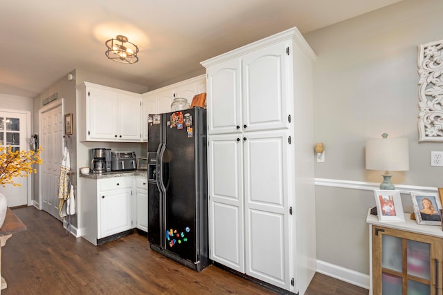 kitchen featuring white cabinets, black fridge, and dark wood-type flooring