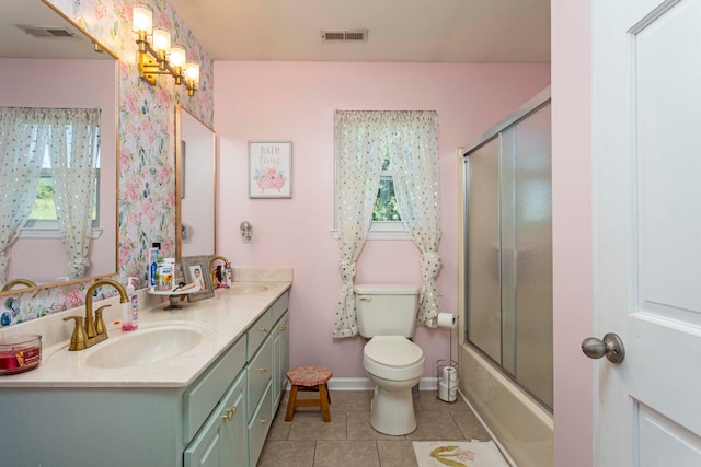 full bathroom with tile patterned floors, bath / shower combo with glass door, vanity, a chandelier, and toilet