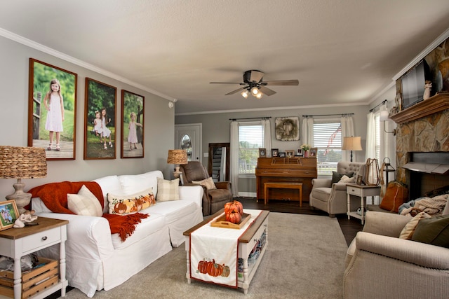 living room featuring hardwood / wood-style floors, ceiling fan, crown molding, and a fireplace