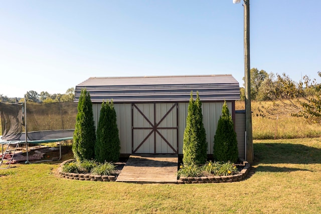 view of outdoor structure featuring a trampoline and a yard