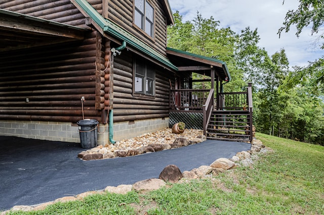 view of property exterior with a lawn and a wooden deck