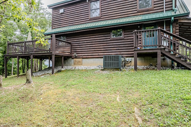 rear view of house featuring a yard, cooling unit, and a deck