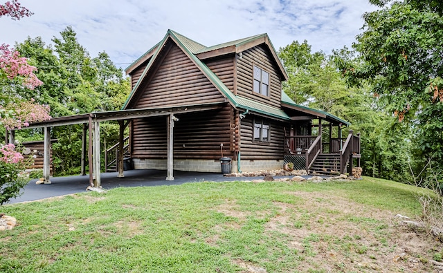 rear view of property featuring a carport and a yard