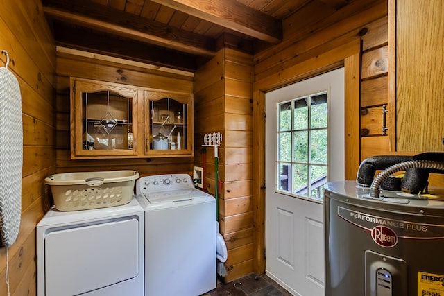 clothes washing area featuring wood walls, washing machine and dryer, electric water heater, and wood ceiling