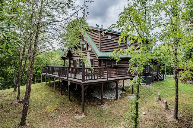 back of house featuring a lawn and a deck