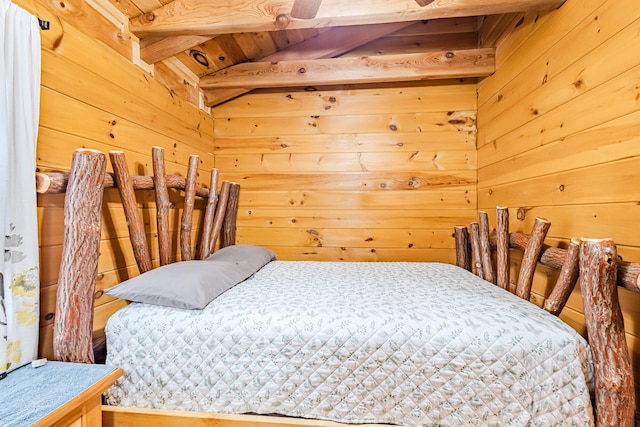 bedroom featuring lofted ceiling with beams and wood walls