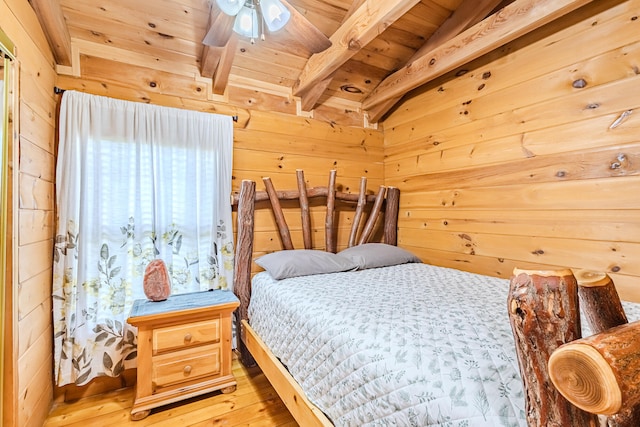 bedroom featuring ceiling fan, wooden ceiling, vaulted ceiling with beams, light hardwood / wood-style floors, and wooden walls