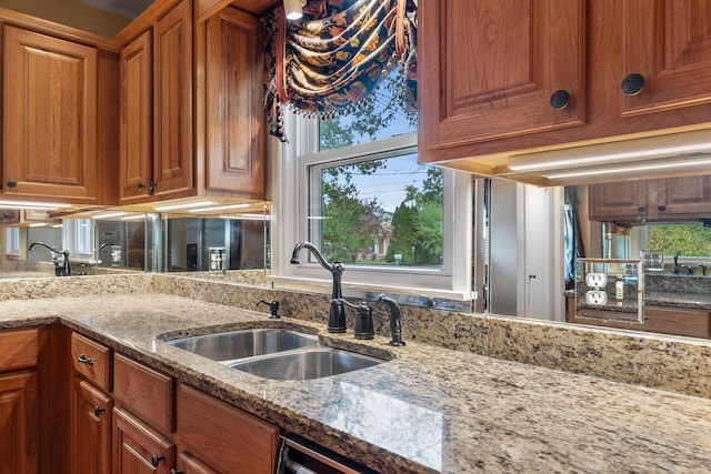 kitchen featuring light stone counters and sink