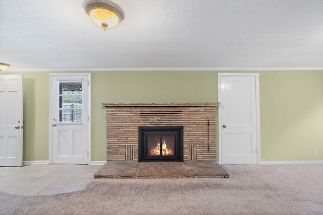 unfurnished living room featuring a stone fireplace, light colored carpet, a textured ceiling, and ornamental molding