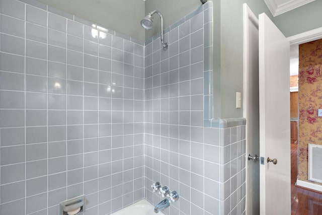 bathroom with hardwood / wood-style floors, tiled shower / bath combo, and ornamental molding