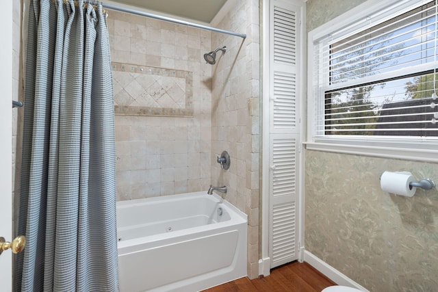 bathroom with hardwood / wood-style floors and shower / tub combo with curtain