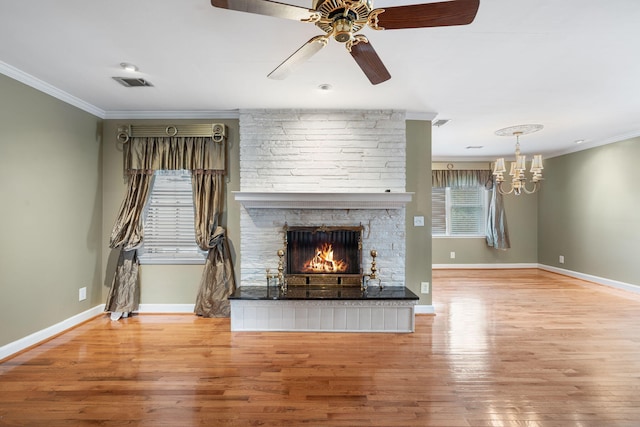 unfurnished living room with a stone fireplace, crown molding, and light hardwood / wood-style flooring