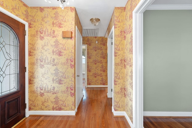 entryway with light hardwood / wood-style flooring and ornamental molding