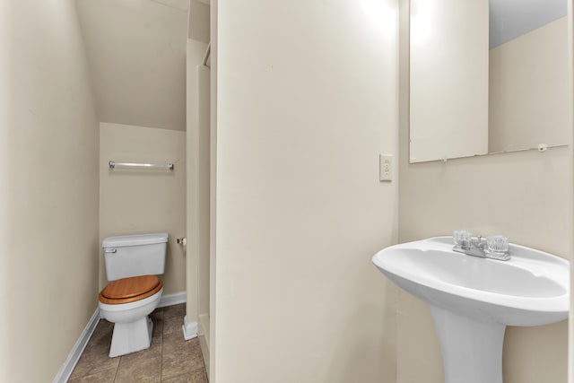 bathroom featuring toilet, baseboards, and tile patterned floors