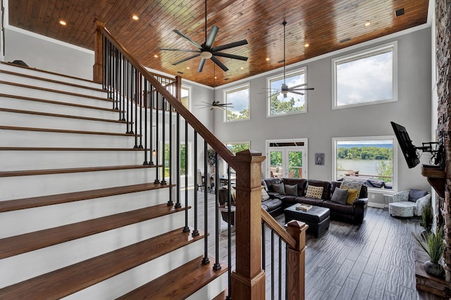 living room with crown molding, ceiling fan, a towering ceiling, dark hardwood / wood-style flooring, and wood ceiling