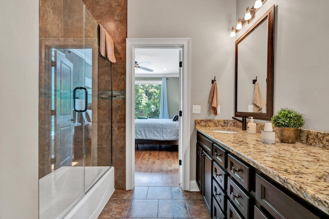 bathroom with shower / bath combination with glass door, ceiling fan, hardwood / wood-style floors, and vanity