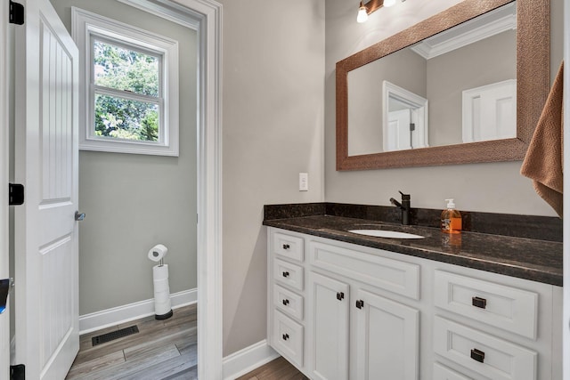 bathroom with vanity, wood-type flooring, and ornamental molding