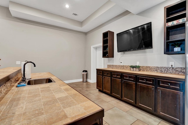 kitchen featuring sink, light tile patterned floors, and dark brown cabinets