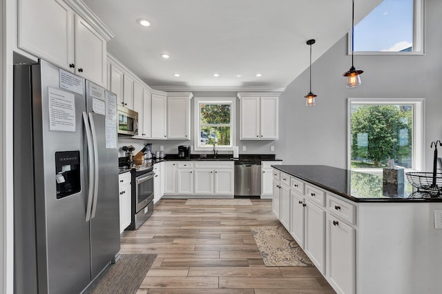 kitchen featuring pendant lighting, white cabinetry, and stainless steel appliances