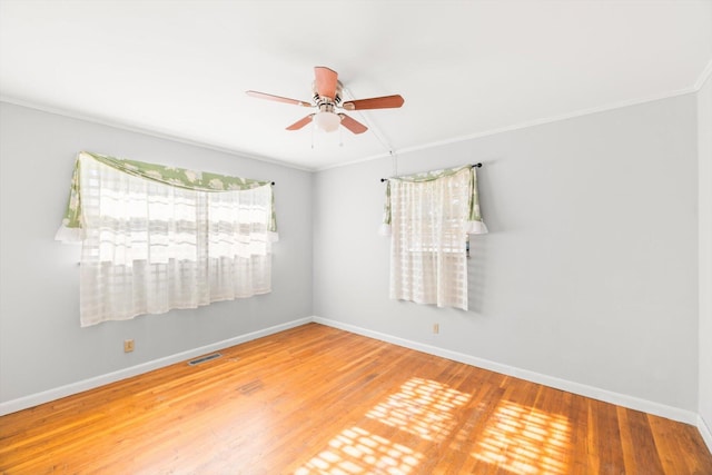 empty room featuring ceiling fan, wood-type flooring, and crown molding