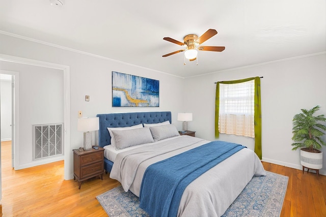 bedroom featuring ceiling fan, ornamental molding, and wood-type flooring