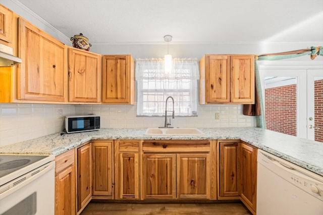 kitchen with decorative light fixtures, sink, white appliances, and tasteful backsplash