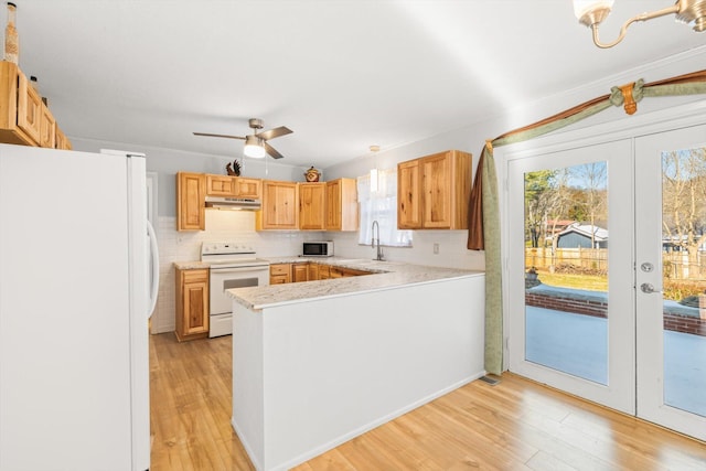 kitchen with tasteful backsplash, a wealth of natural light, and white appliances