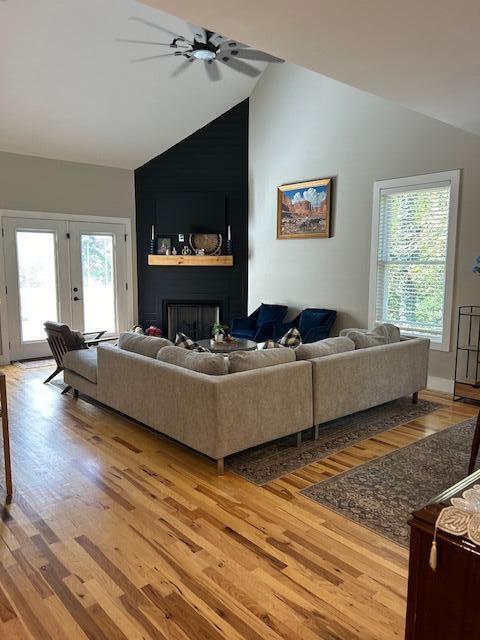 living room featuring a wealth of natural light, light hardwood / wood-style flooring, ceiling fan, and french doors