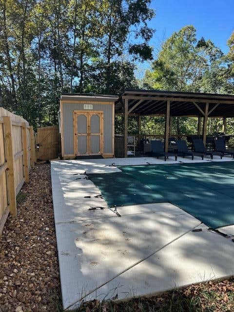 view of patio featuring a storage unit and a covered pool