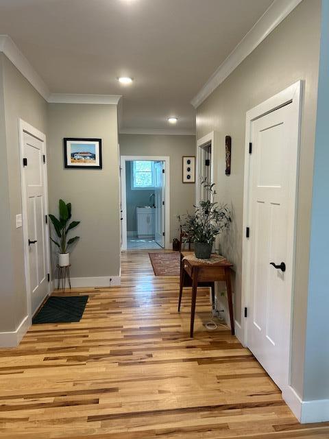 interior space featuring crown molding and light hardwood / wood-style flooring