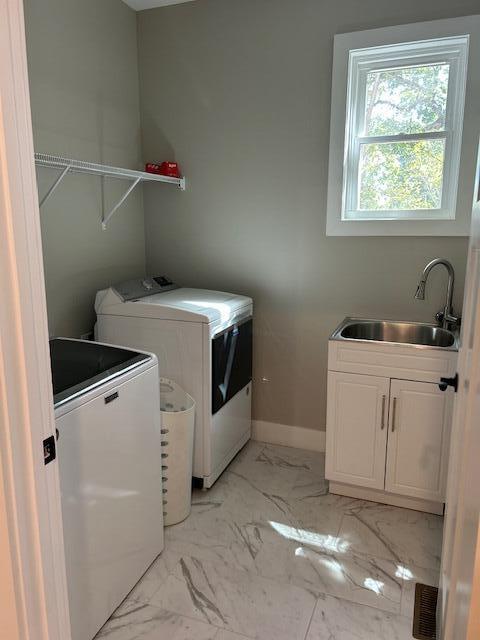 laundry room featuring washer and clothes dryer, cabinets, and sink