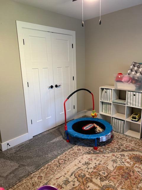 playroom with ceiling fan and carpet floors