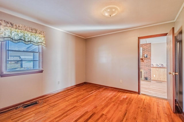 empty room with baseboards, light wood-style flooring, visible vents, and crown molding