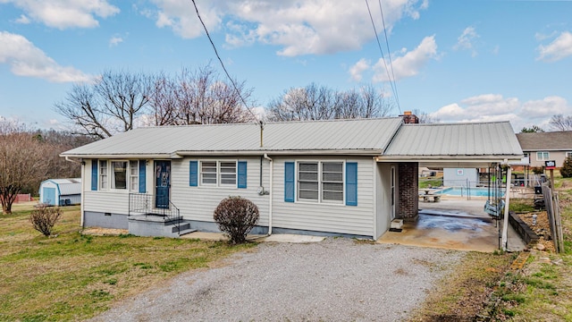 view of front of property with metal roof, a carport, crawl space, and gravel driveway