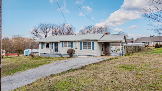 view of front of home featuring driveway, metal roof, an attached carport, crawl space, and a front lawn