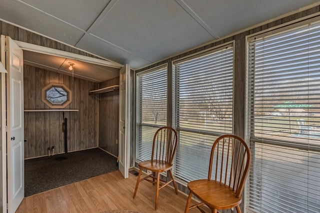 sitting room featuring wood walls and light wood-type flooring