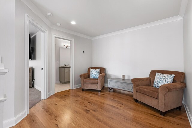 living area featuring hardwood / wood-style floors and crown molding