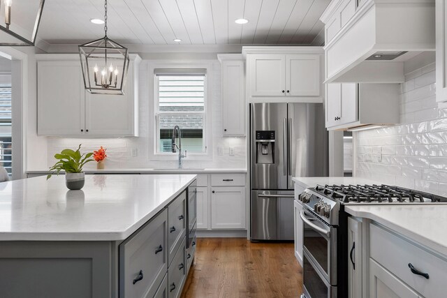 kitchen featuring stainless steel appliances, white cabinetry, premium range hood, and sink