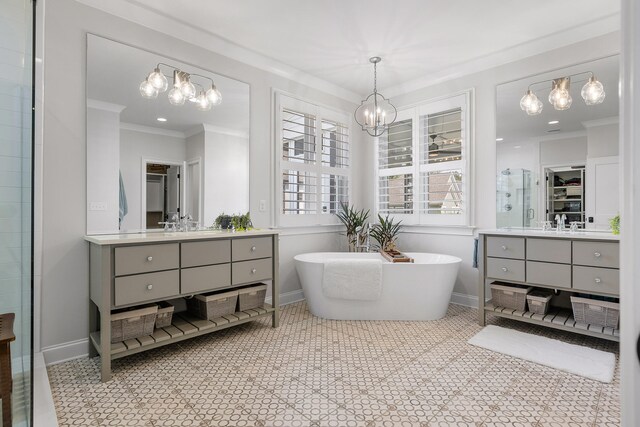 bathroom with a chandelier, a bath, vanity, and crown molding