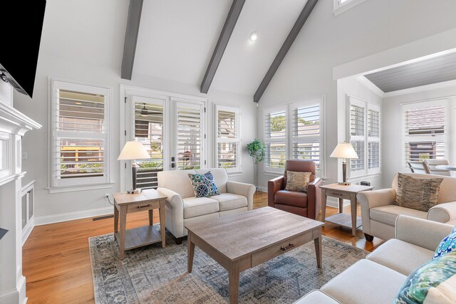 living room featuring beam ceiling, plenty of natural light, high vaulted ceiling, and light hardwood / wood-style flooring